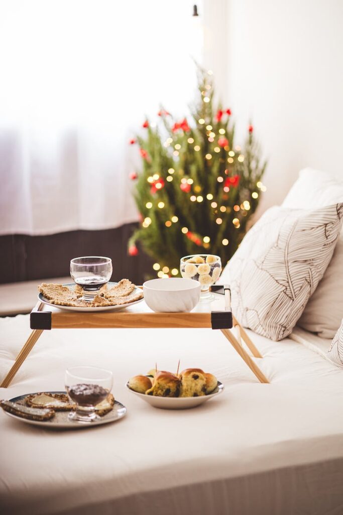 A tray with food and drinks on a bed