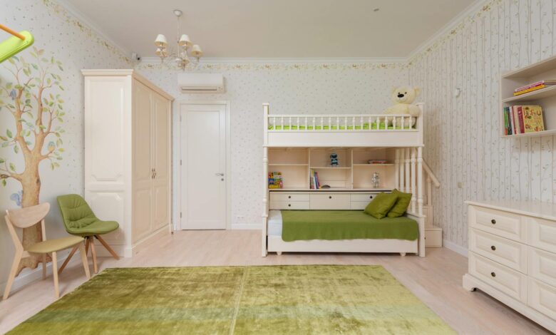 Interior of cozy light bedroom for kid with double deck bed and wooden shelves with decorations and green carpet