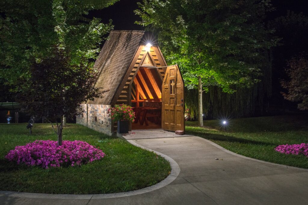 empty pathway leading to a house with open door at night