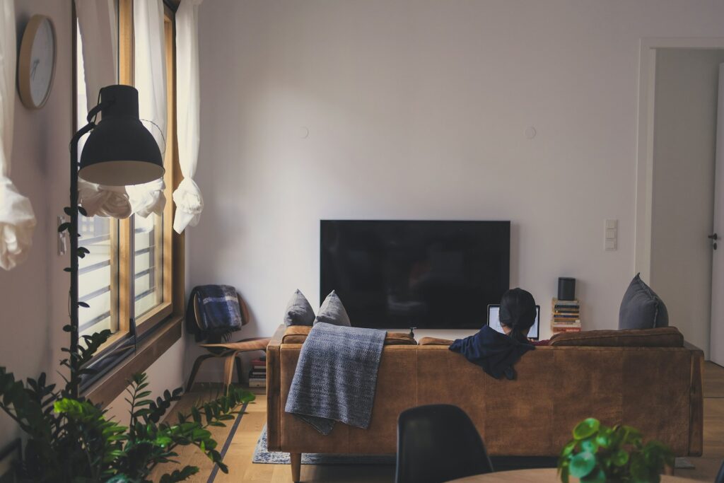 woman sitting on couch in front of LED TV