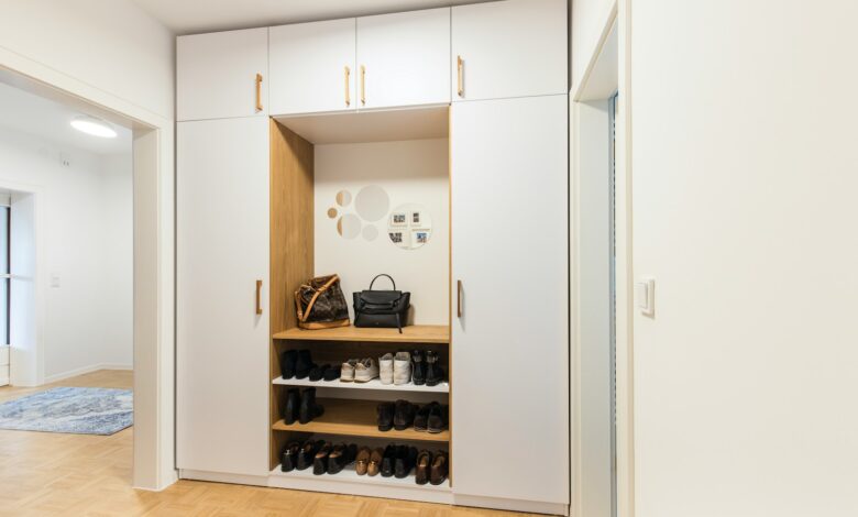 a white closet with a shoe rack and a handbag